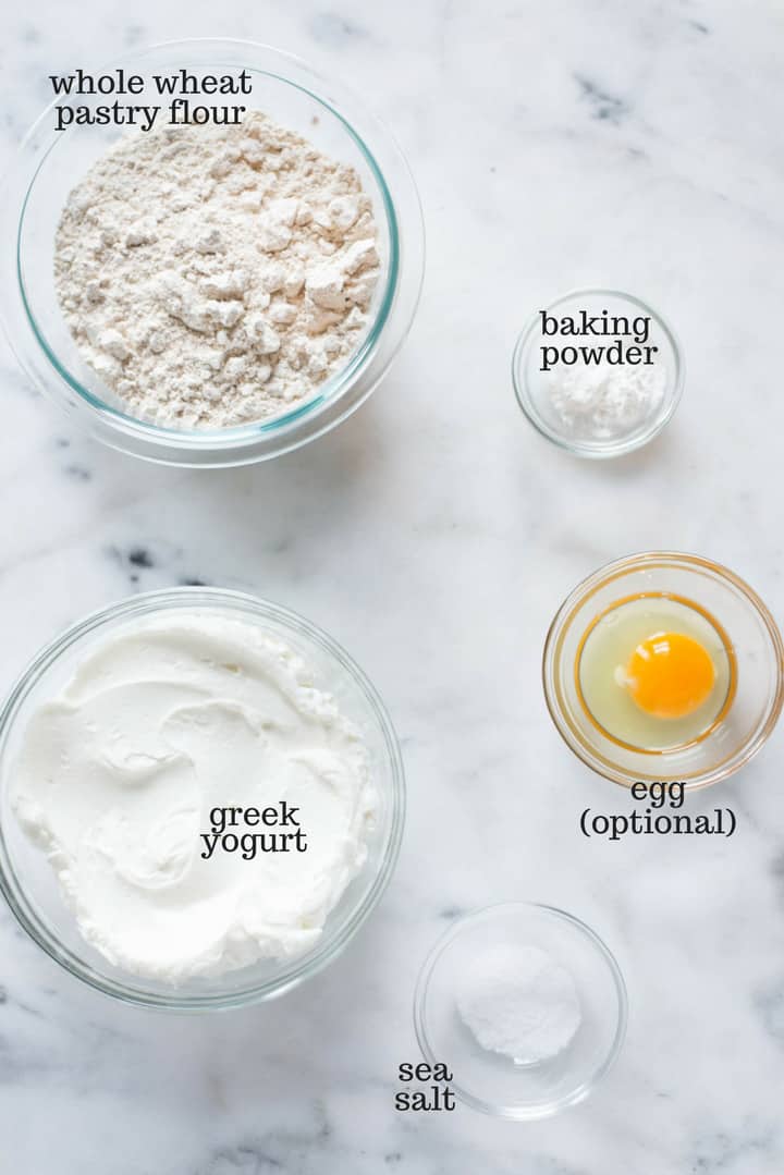 The only four ingredients that are needed to make the homemade bagel recipe, including whole wheat pastry flour, greek yogurt, baking powder, and sea salt, plus an optional egg.