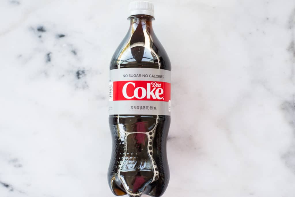 Overhead view of a bottle of soda; aspartame is found in soda and is one of 10 Foods That Cause Inflammation.