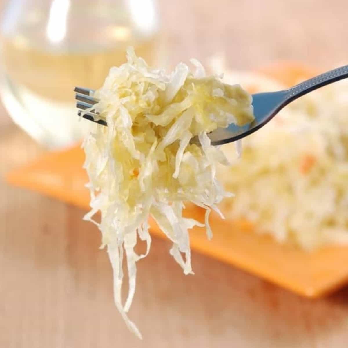 Close up side view of a glass jar full to the brim with ready to eat sauerkraut.
